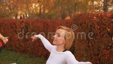 健身女子在秋季公园的芭蕾舞课上跳舞。 体育女子训练舞蹈锻炼在秋季公园。 慢动作